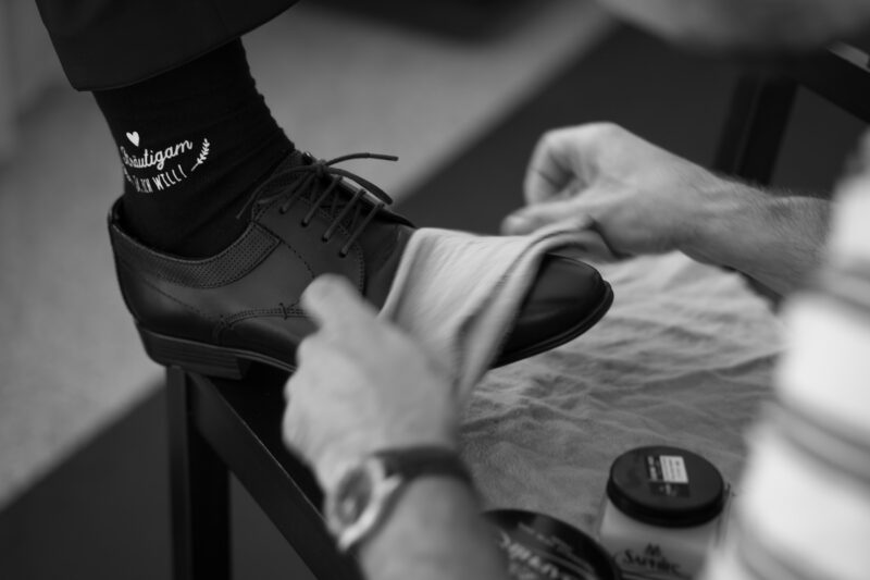 Schuhe des Bräutigams werden mit weißem Tuch poliert