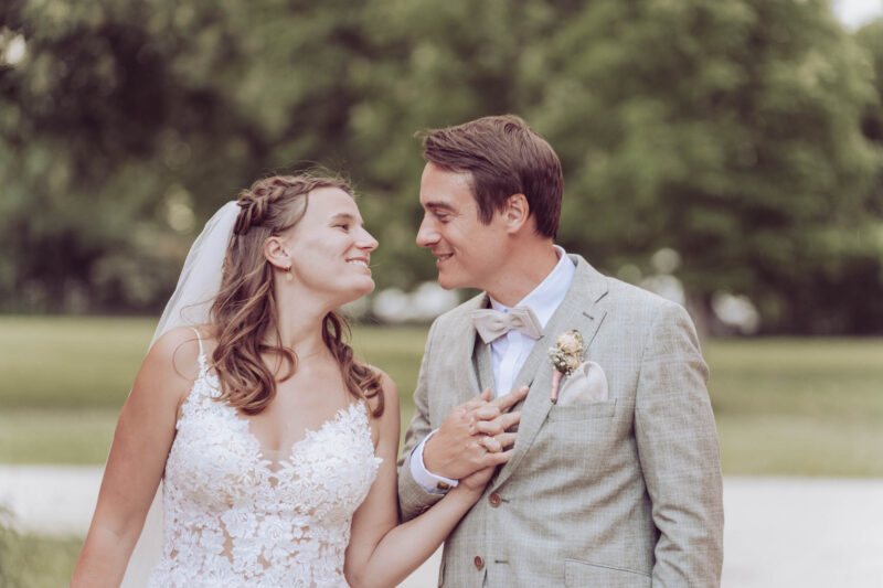 Brautpaar hält sich an der Hand und schaut sich verliebt in die Augen