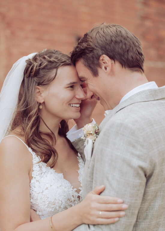 Hochzeitspaar lächelt und schaut sich verliebt in die Augen