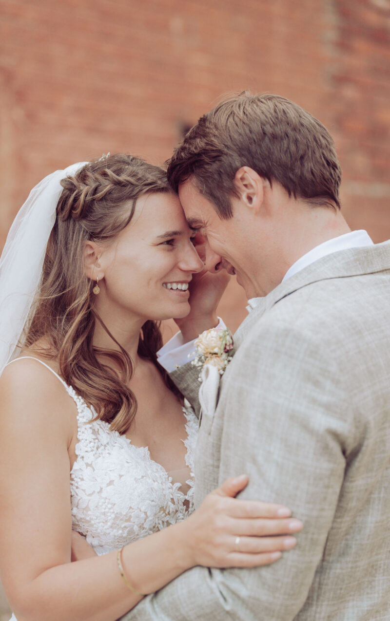 Hochzeitspaar lächelt und schaut sich verliebt in die Augen