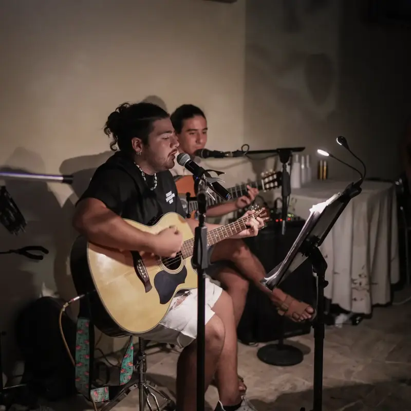 Sänger sitzt und spielt gleichzeitig Gitarre