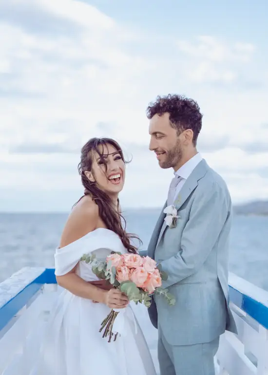 Bräutigam hält Braut in den Armen und schaut sie verliebt an, während sie herzig lacht