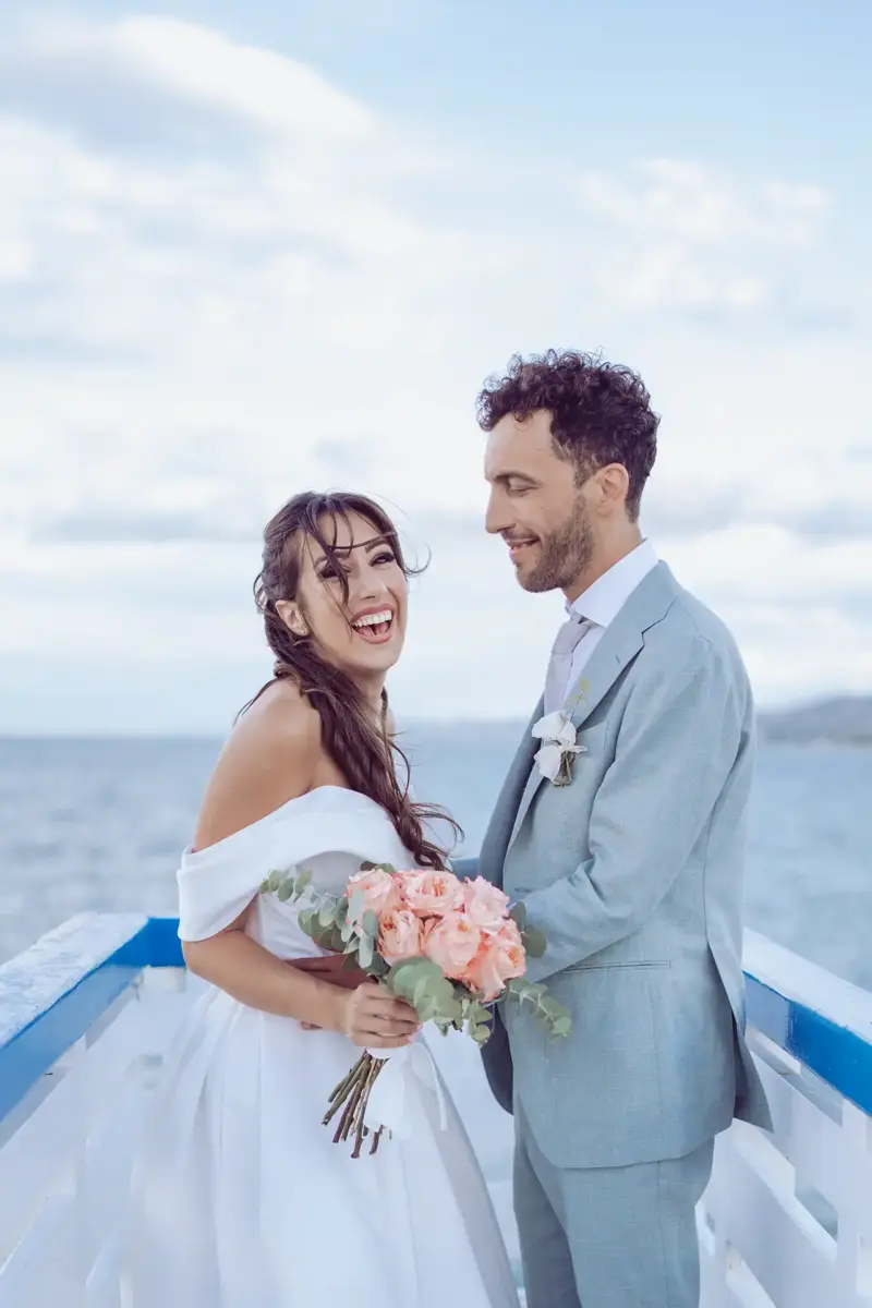 Bräutigam hält Braut in den Armen und schaut sie verliebt an, während sie herzig lacht