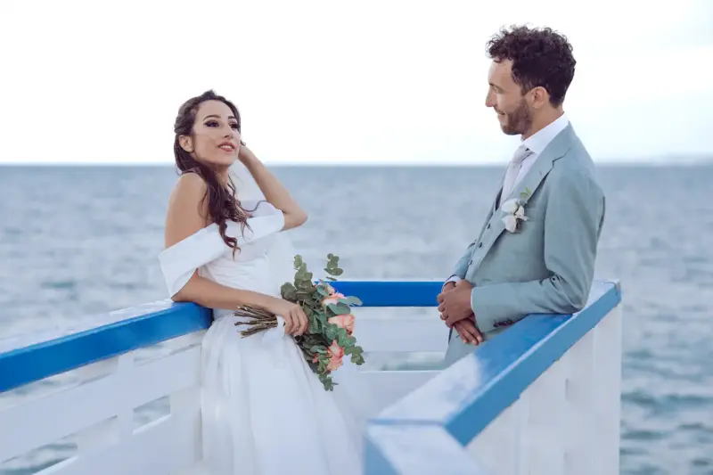 Braut posiert auf dem blau-weißen Steg am Hafen