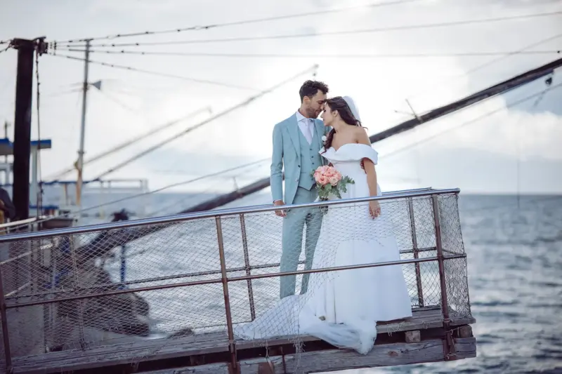 Braut und Bräutigam stehen am Hafen auf Steg Stirn an Stirn