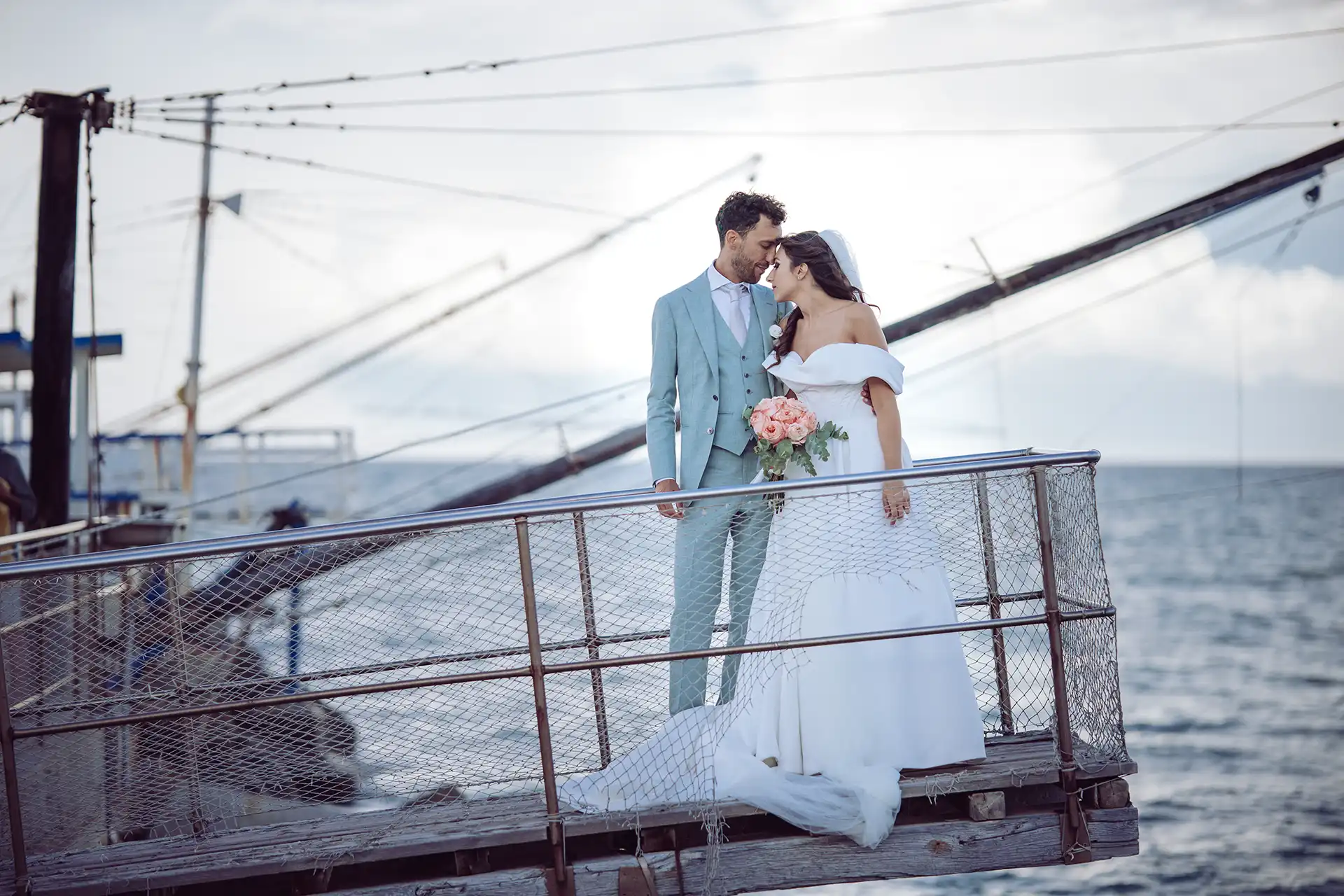 Braut und Bräutigam stehen am Hafen auf Steg Stirn an Stirn