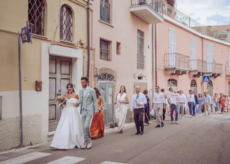 Brautpaar und Hochzeitsgäste laufen auf der Straße in Giulianova