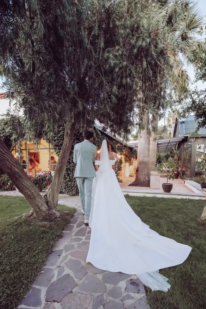 Brautpaar läuft vom Fotografen weg Richtung Hochzeitslocation