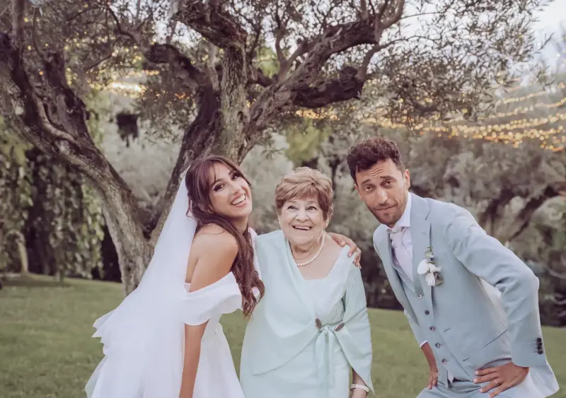Brautpaar posen zusammen mit der Oma vor Olivenbaum