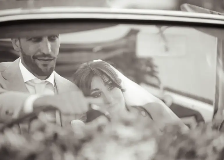 Brautpaar sitzt im Cabrio und schaut auf die Straße, Schwarz-Weiß