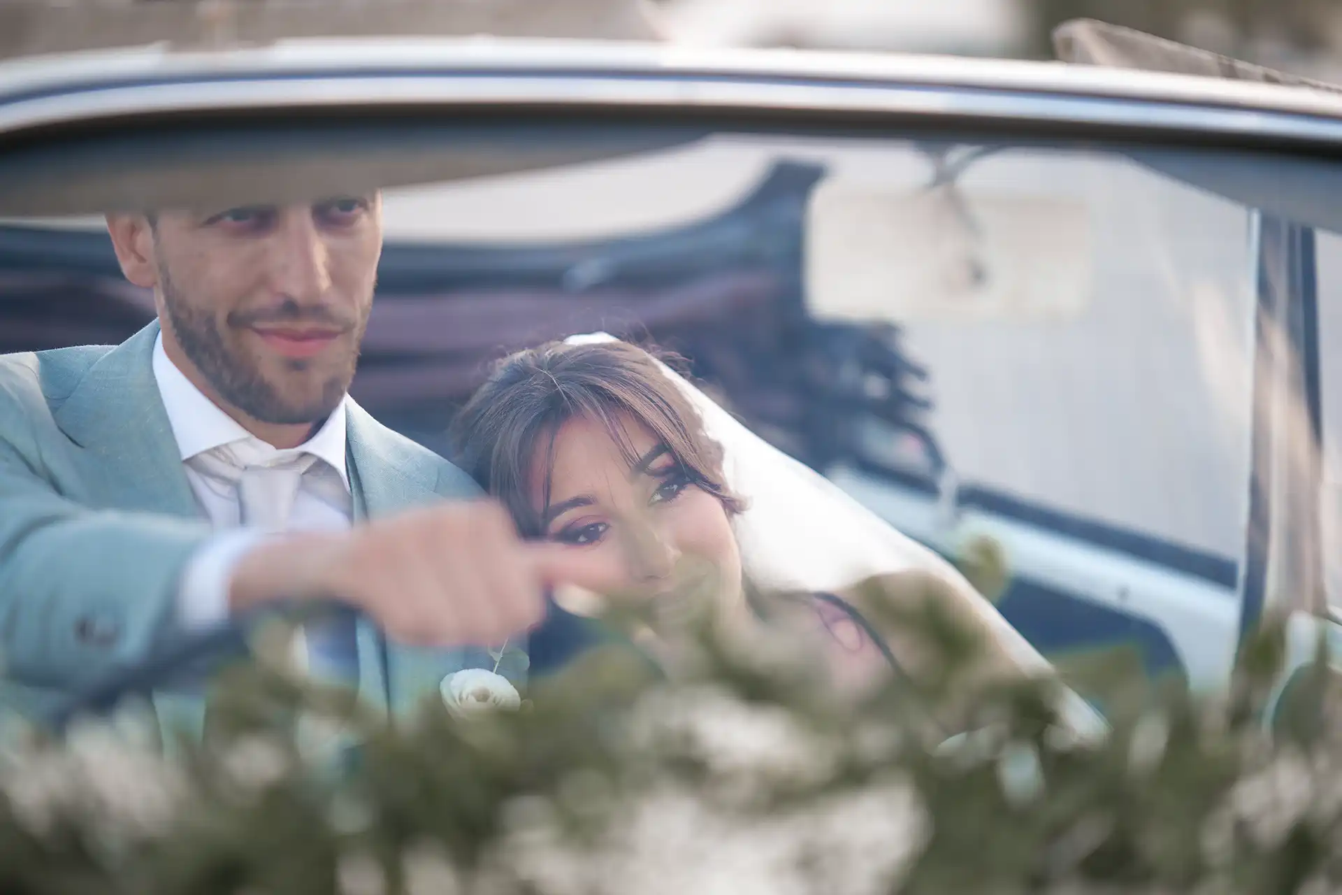 Brautpaar sitzt im Cabrio und schaut auf die Straße
