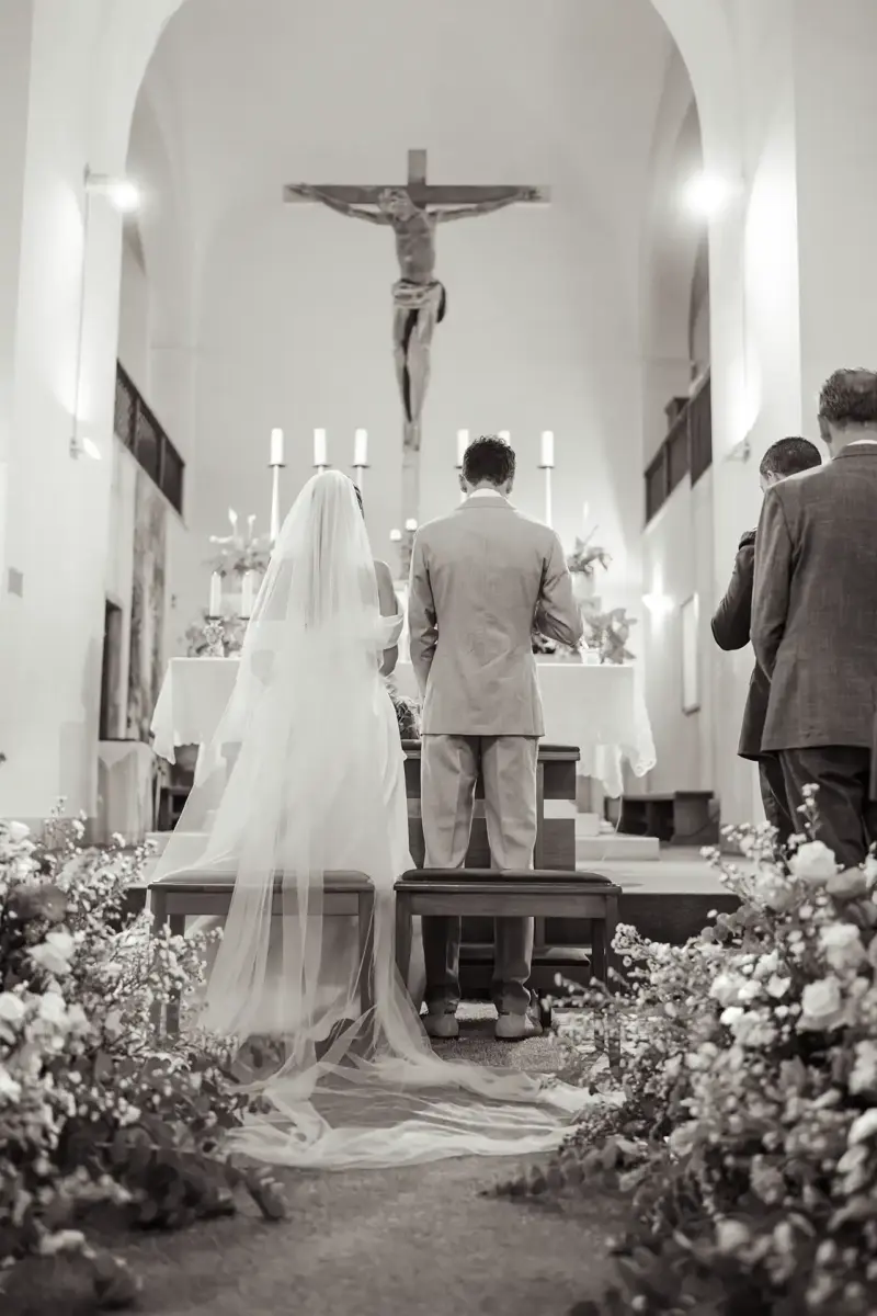 Brautpaar vor Altar mit Kreuz Jesu im Hintergrund, Schwarz-Weiß