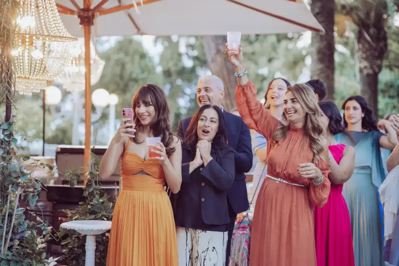 Hochzeitsgäste mit bunten Kleidern jubeln