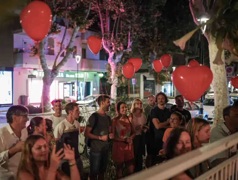 Gäste stehen mit Herzluftballons auf Gehsteig