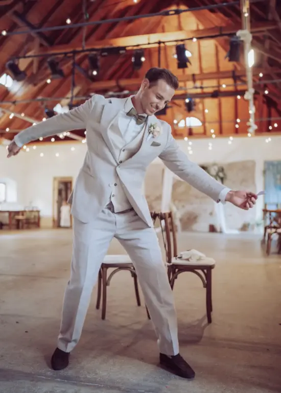 Bräutigam spielt lachend die Luftguitarre in der Remise Schloß Fußberg