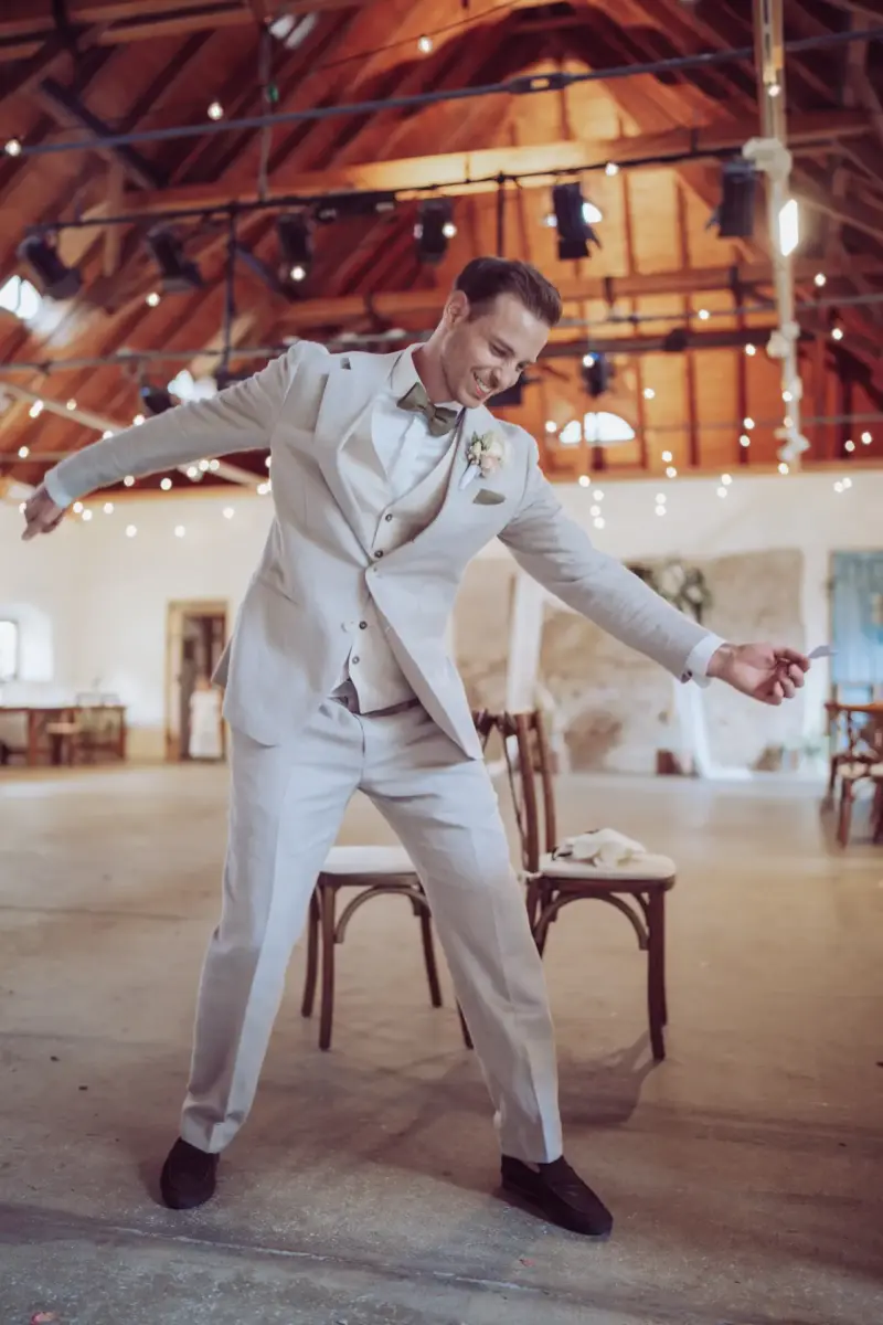 Bräutigam spielt lachend die Luftguitarre in der Remise Schloß Fußberg