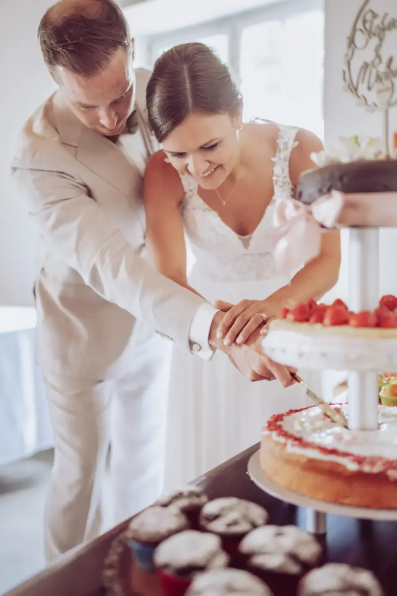 Brautpaar schneidet die Hochzeitstorte an