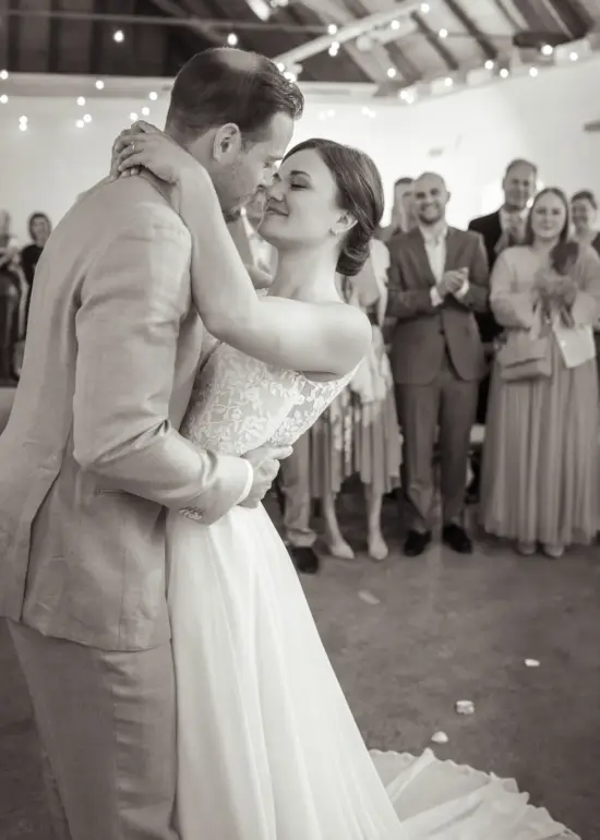 Brautpaar umarmt sich eng vor den Gästen während der Trauung in der Remise Schloß Fußberg