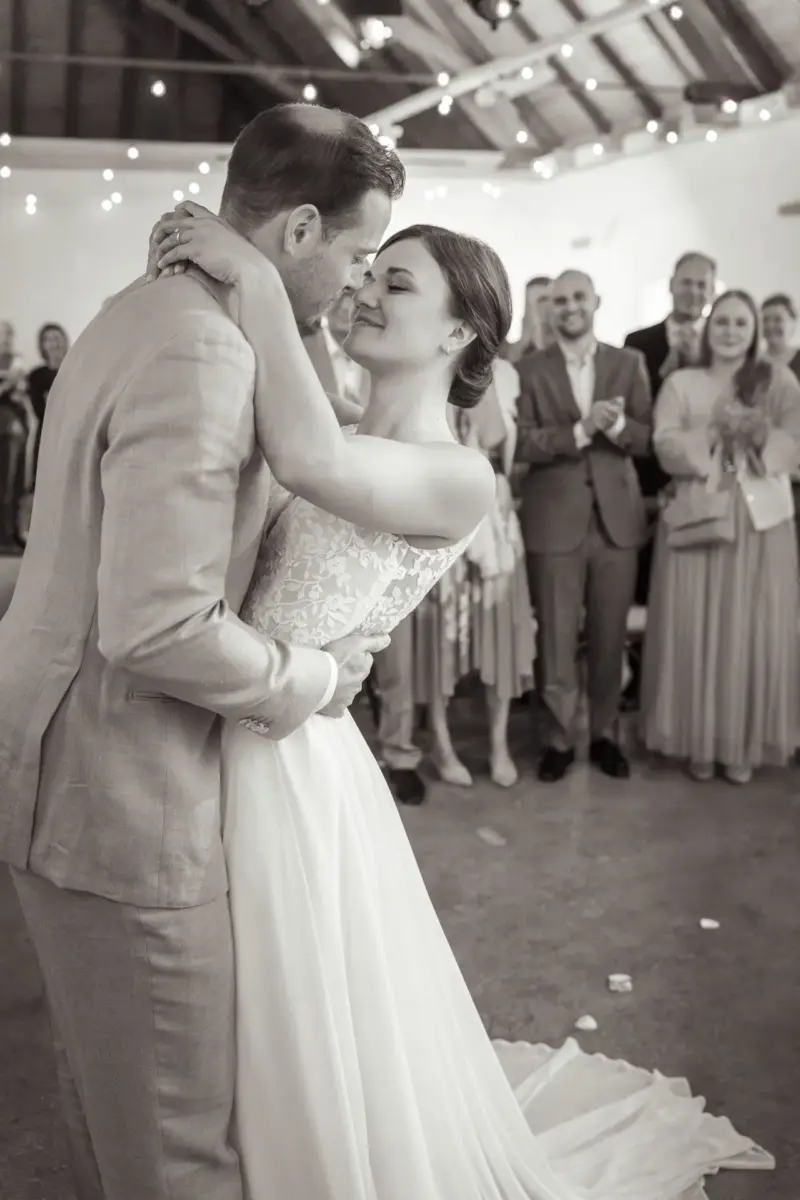 Brautpaar umarmt sich eng vor den Gästen während der Trauung in der Remise Schloß Fußberg