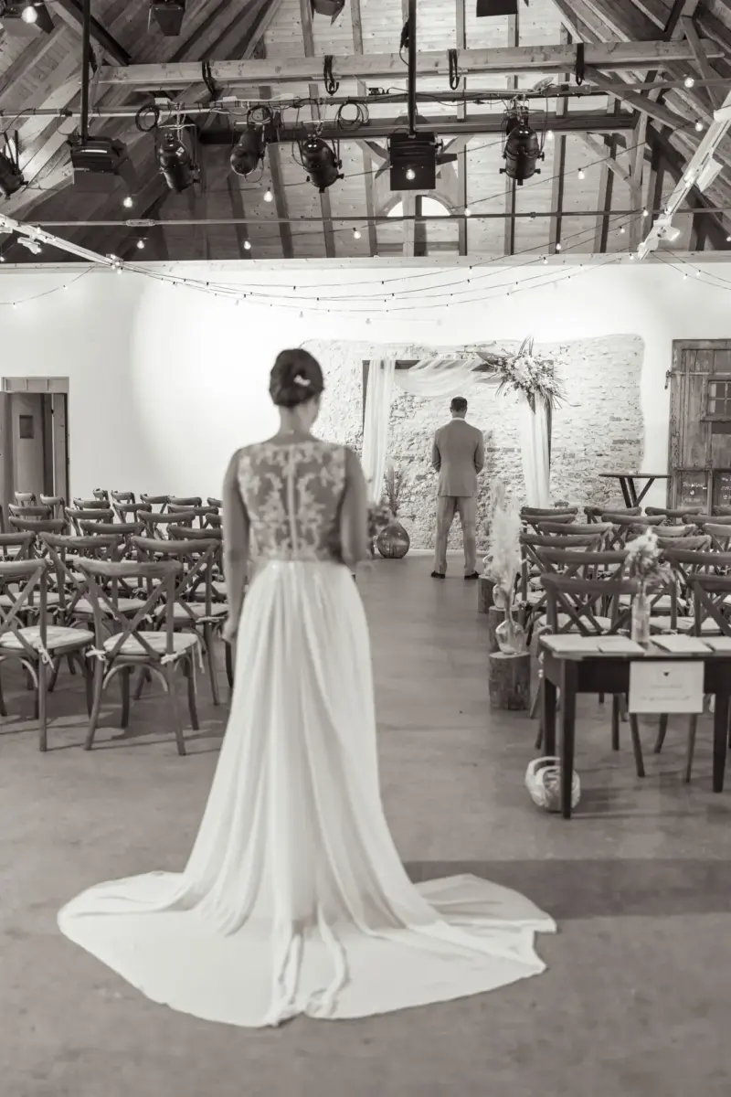 Bräutigam steht mit dem Rücken zur Braut vor dem First Look in der Remise Schloß Fußberg