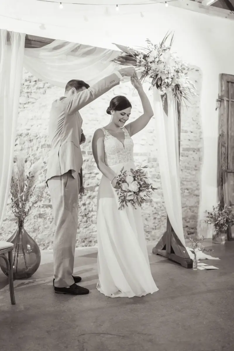 Brautpaar tanzt beim First Look unter dem Traubogen