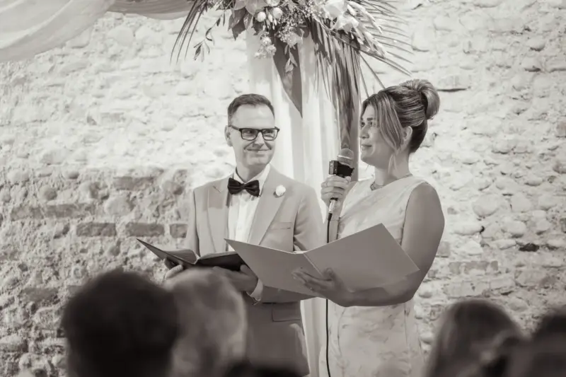 Die Traurednerin steht vor dem Traubogen und weint