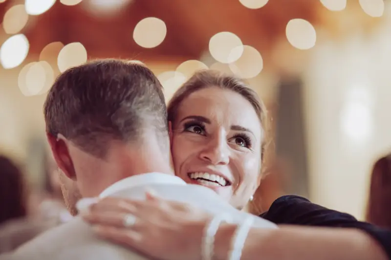 Hochzeitsgast umarmt den Bräutigam und strahlt