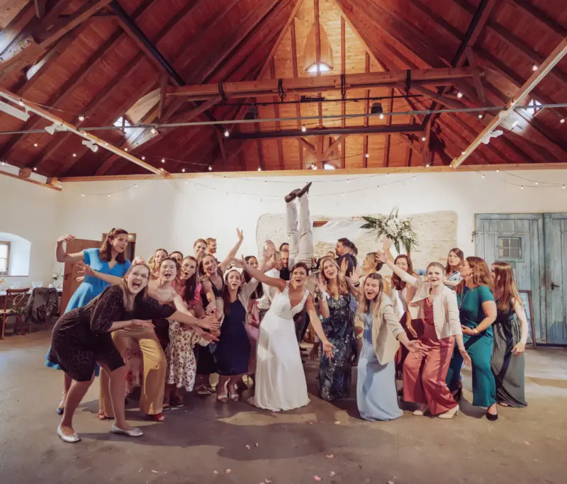 Gruppenbild der Hochzeitsgäste, der Bräutigam macht einen Handstand