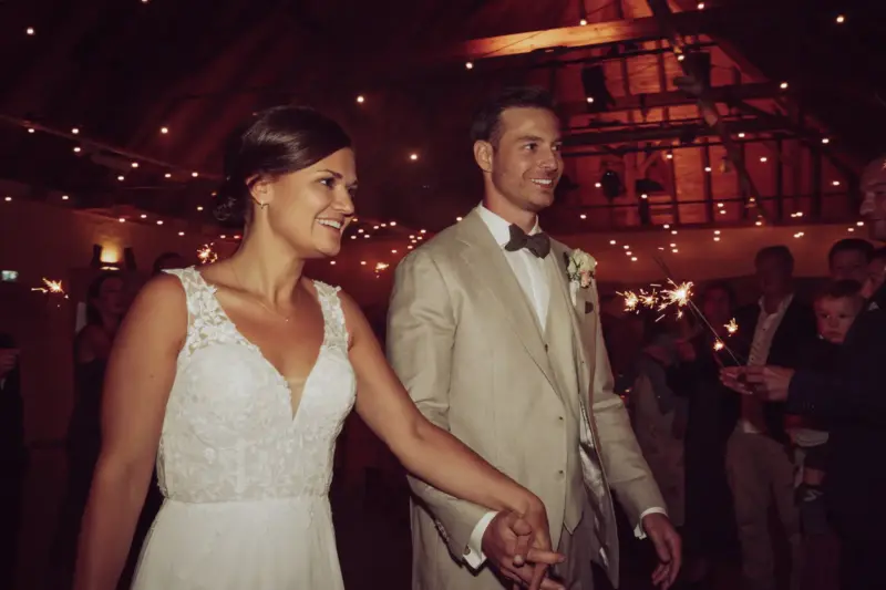 Brautpaar läuft zwischen brennenden Wunderkerzen entlang